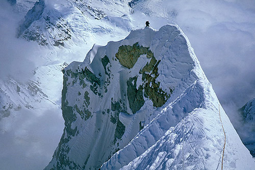 Classic Snow and Ice Climbs of the Alaska Range - Photo Slideshow Image #1 - by Joseph Puryear. Mark Westman climbing along the knife-edge ridge section of Mt. Foraker’s Infinite Spur. [akfoinfi]