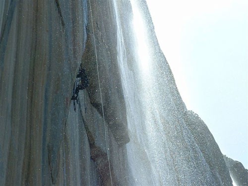 A climber low on the route surrounded by Horsetail Fall. The route is ...