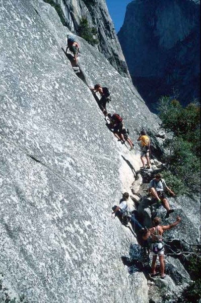 Many soloists passing a party on Royal Arches with Half Dome in the ba...