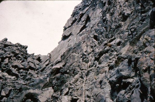 Climbing up the black chossy rock on the west side to a notch.