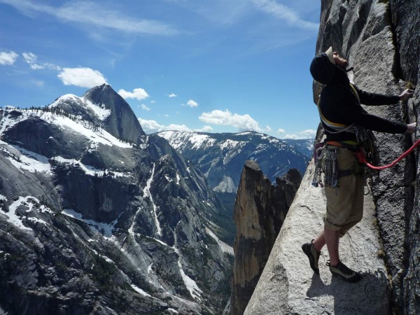 Tommy Caldwell about 4 pitches from the top. Snowy Half Dome in the ba...