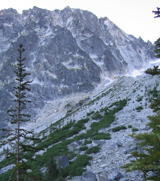 Looking up from Colchuck Lake at the approach talus and the route.  Th...
